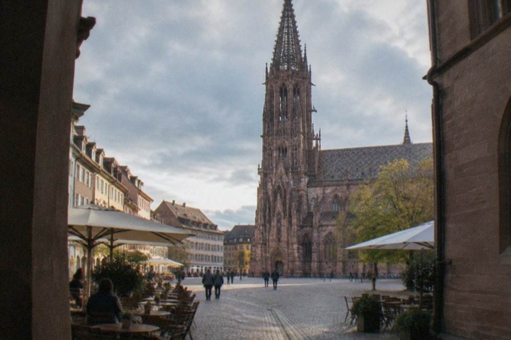 Cobbled lane in central Freiburg with café tables and shop signs