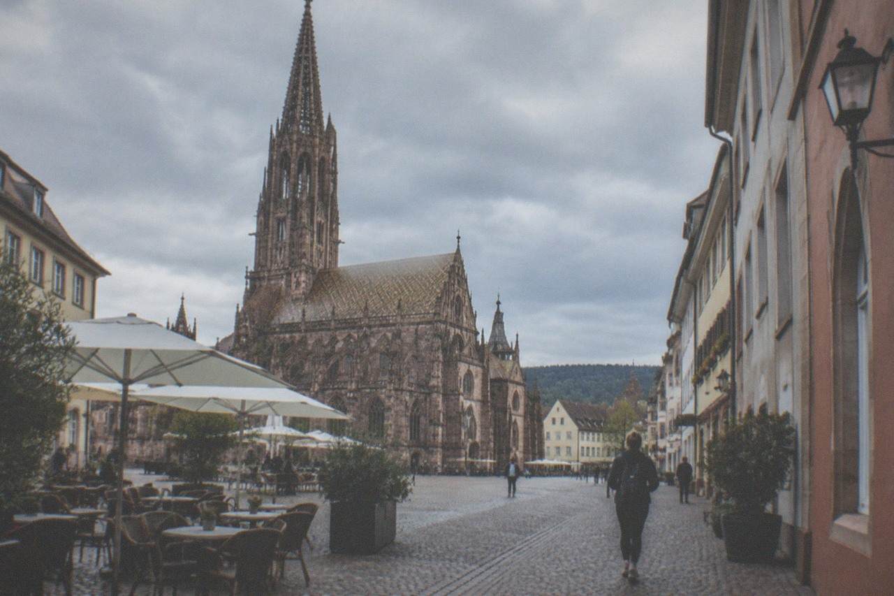 Cobbled lane in central Freiburg with café tables and shop signs