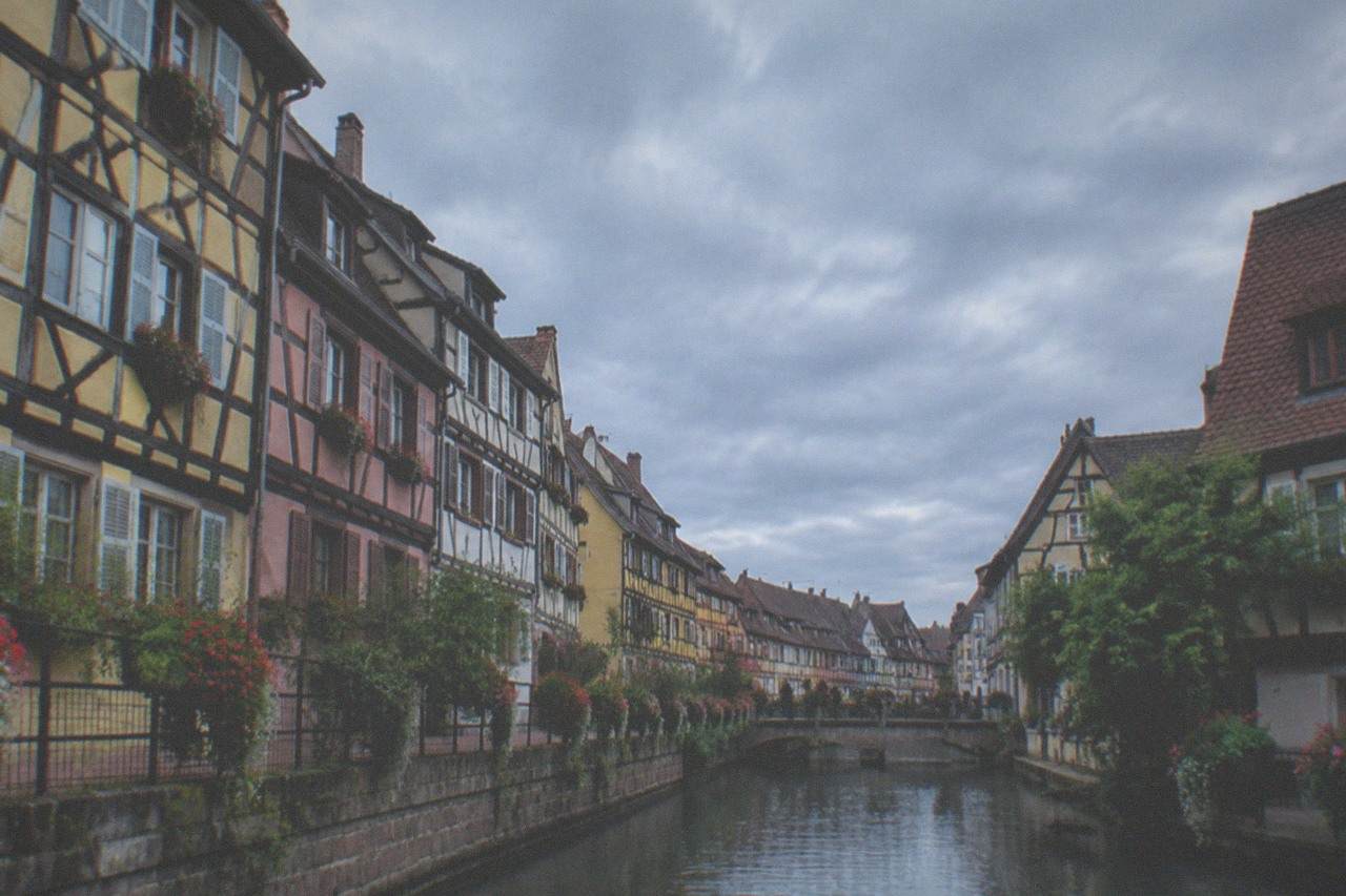 Half-timbered houses along a canal in Colmar old town on a bright day
