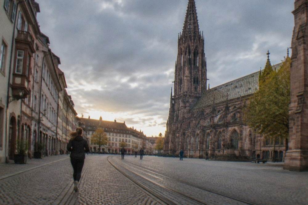 Wide pedestrian shopping street in Freiburg lined with historic facades and tram tracks