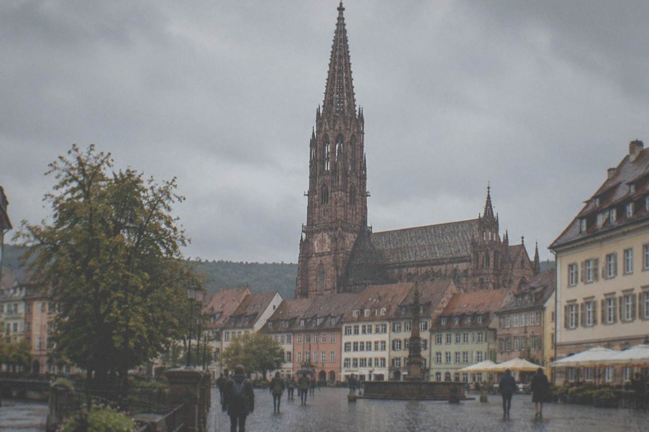 Freiburg old street with the Minster tower rising above red rooftops