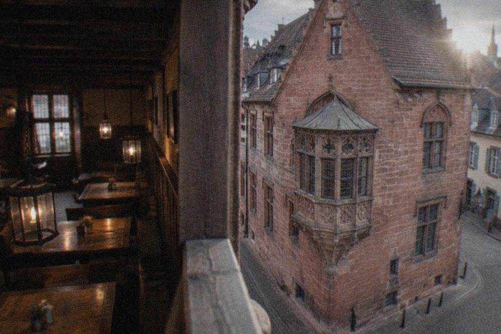 Old tavern interior with wooden tables, benches and hanging lanterns