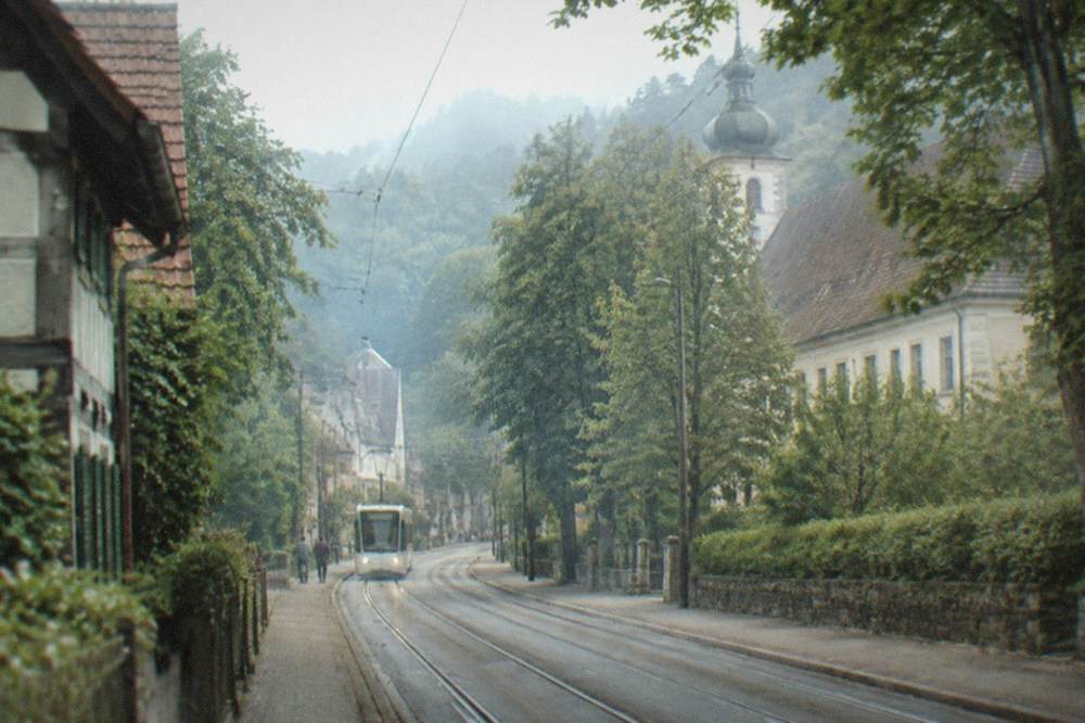 tram tracks running along a tree-lined street toward the city centre