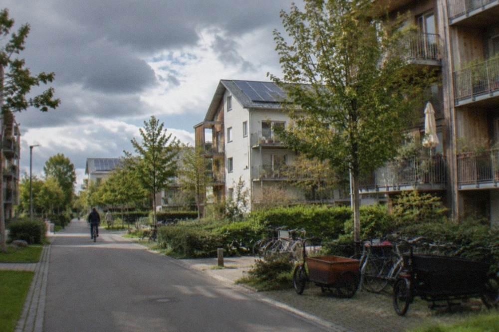 Modern apartment buildings with solar panels on roofs and green lawns in a residential district