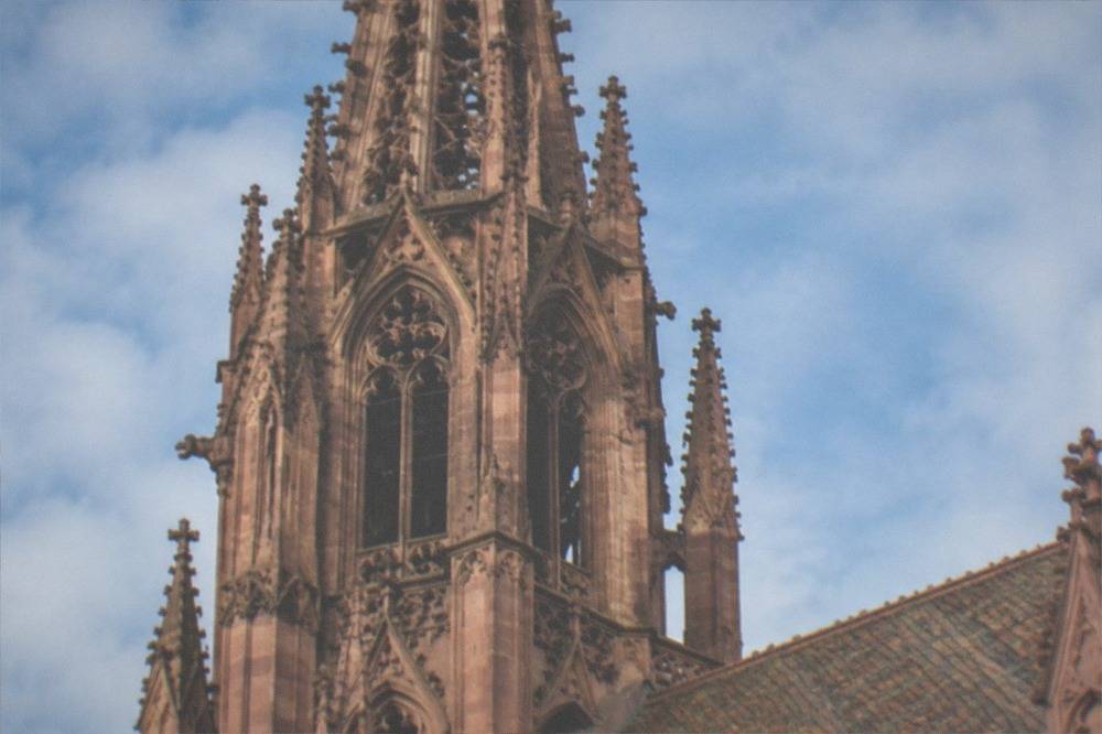 Close view of carved sandstone tracery on the cathedral spire against blue sky