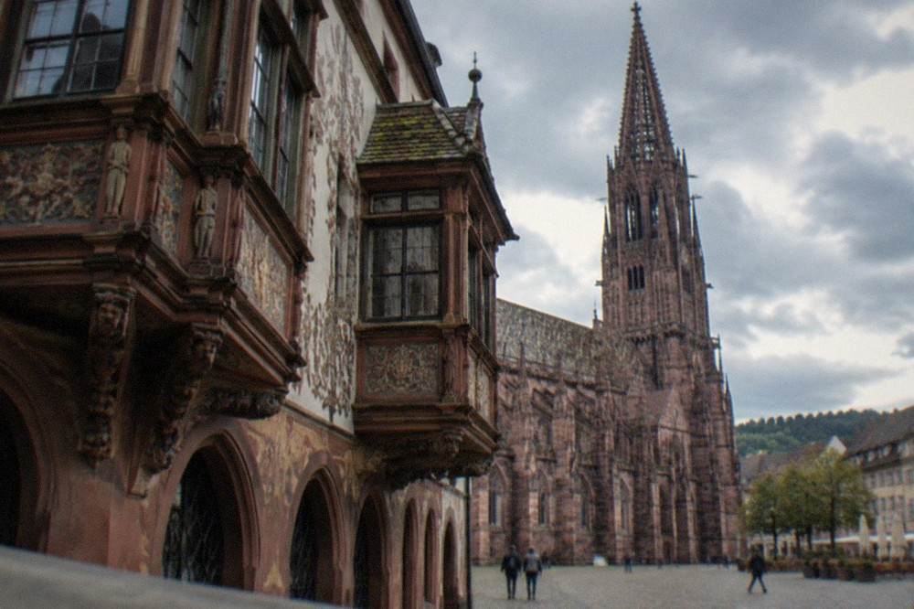 Close view of a historic merchant house facade with carved bay windows and painted decoration in Freiburg