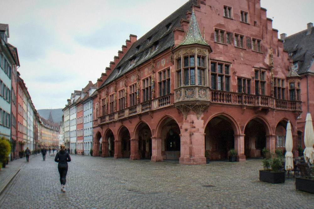 Cobblestone lane in Freiburg's old town lined with colorful painted facades