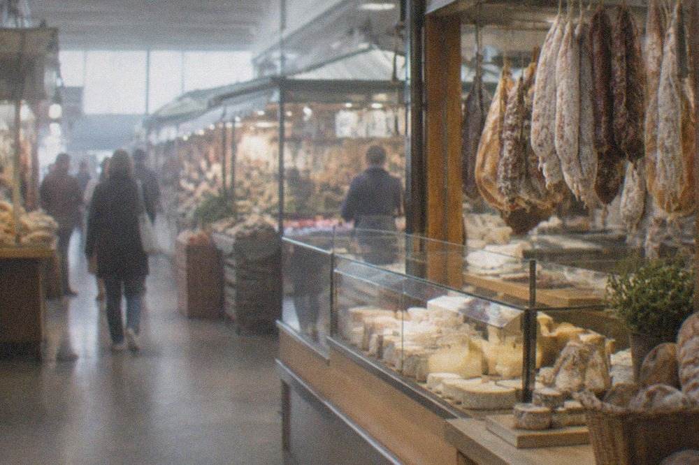 Covered market hall interior with counters of breads, cheeses and cured meats