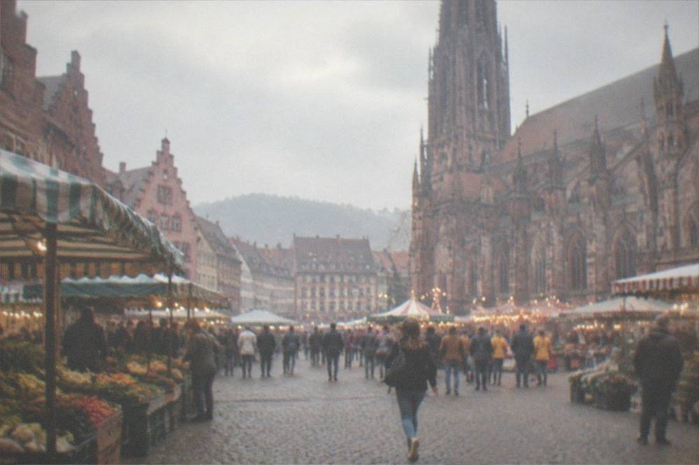 Festival lights and crowded evening stalls on the square in front of the Minster