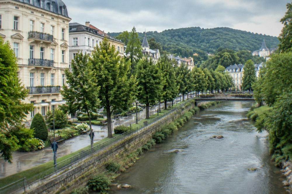 Tree-lined riverside parkway beside a shallow mountain river
