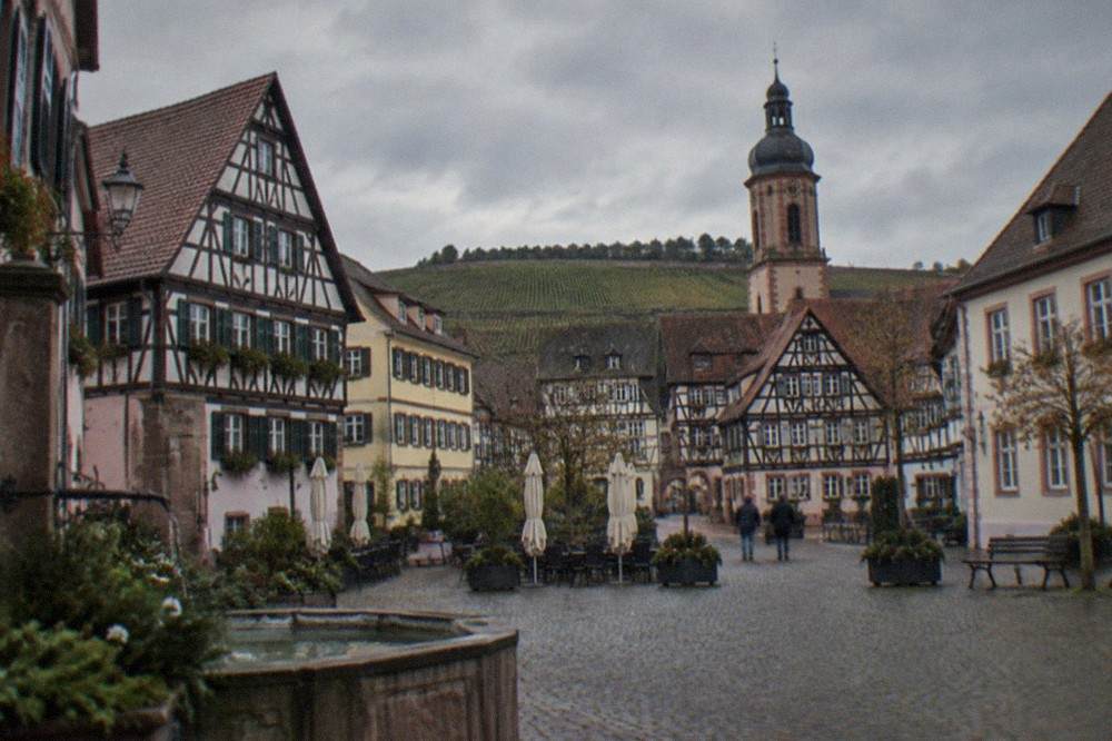 Timber-framed facades around a small market square in the morning