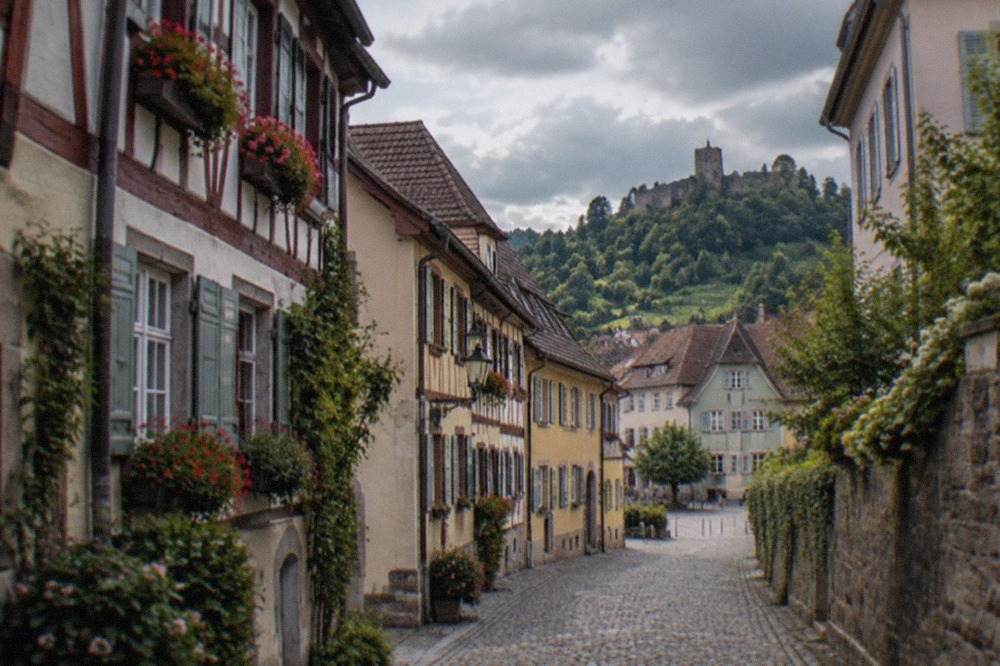 Narrow lane in a small German wine town with painted half-timbered facades and flower boxes