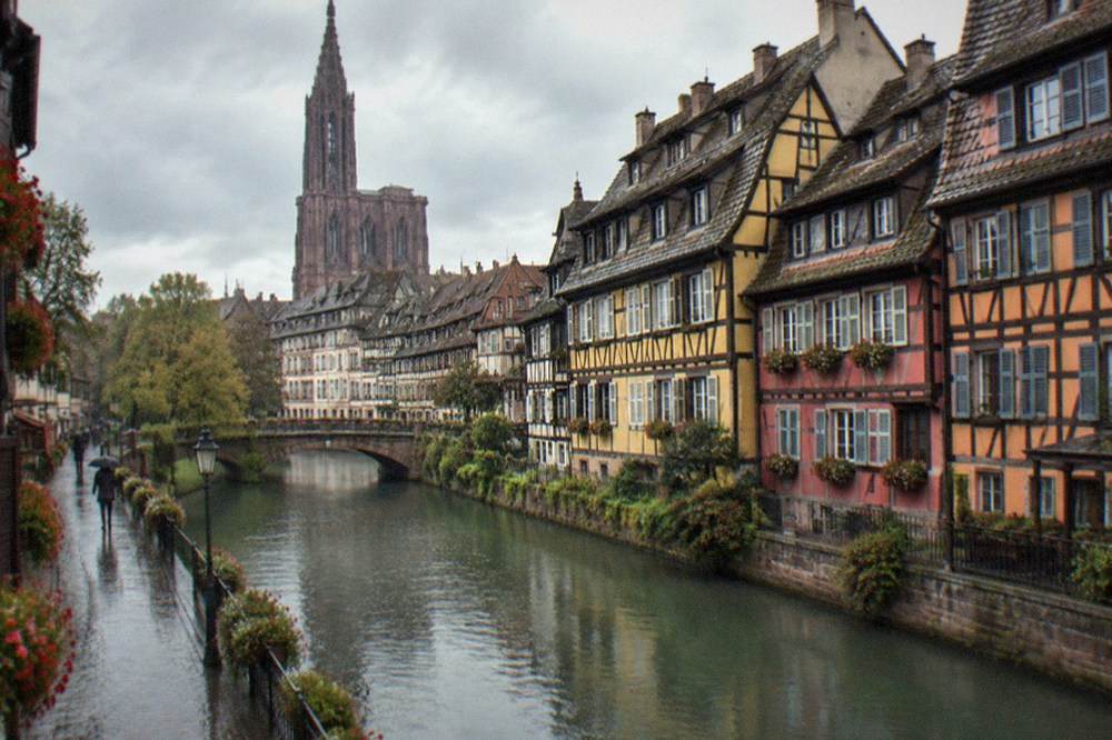 Narrow street of restored half-timbered houses with flower boxes in central Strasbourg