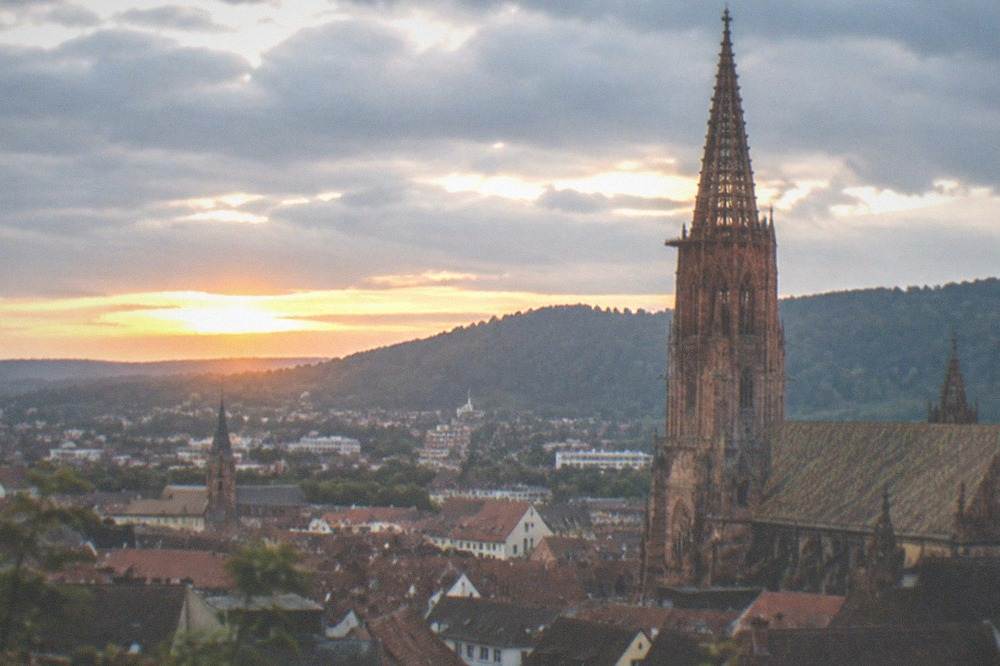 Evening view over Freiburg rooftops toward the Munster tower at dusk