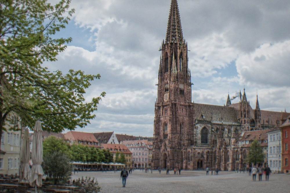 Freiburg Minster rising above red roofs of the old town on a clear day