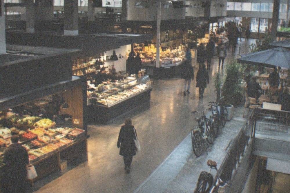 A neighborhood café terrace with bicycles parked against a railing