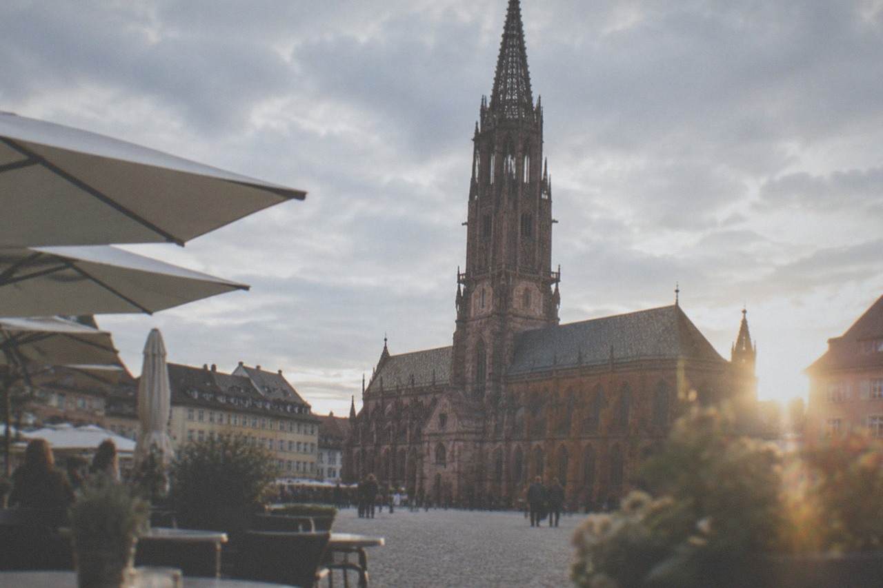 Outdoor tables and café umbrellas on a historic Freiburg square