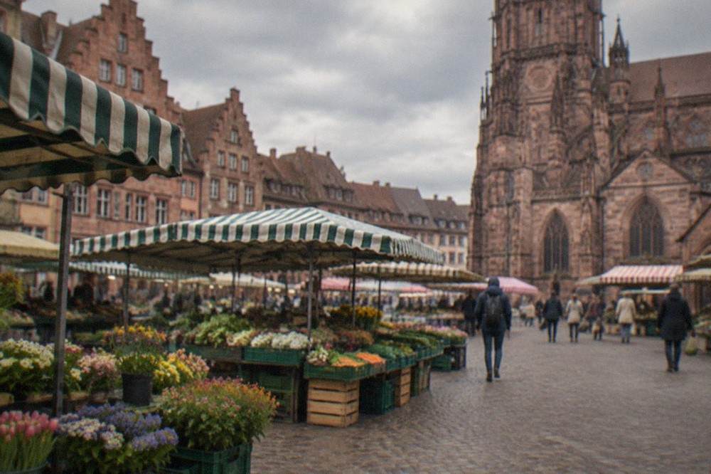 Market stalls with flowers and vegetables on Münsterplatz beside the minster