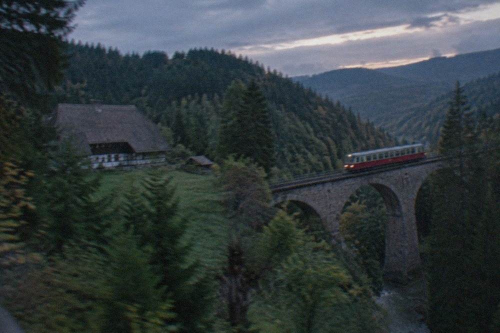 A single-track mountain railway viaduct crossing a wooded valley in the Black Forest
