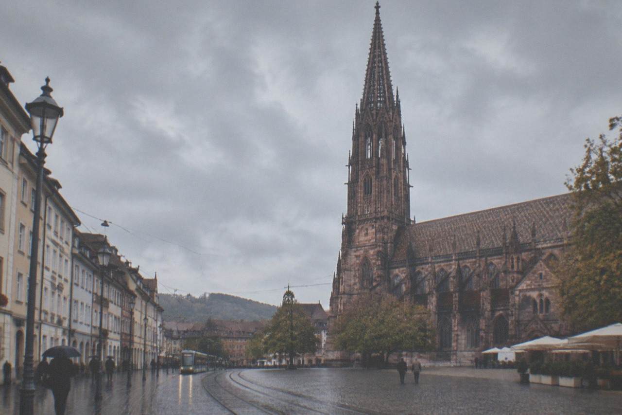 A quiet Freiburg street with tram tracks and the minster tower in the background