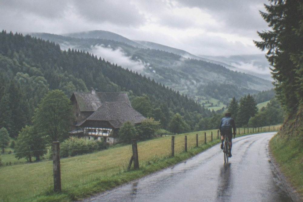 Cyclist on a country road with Black Forest hills rising behind fields