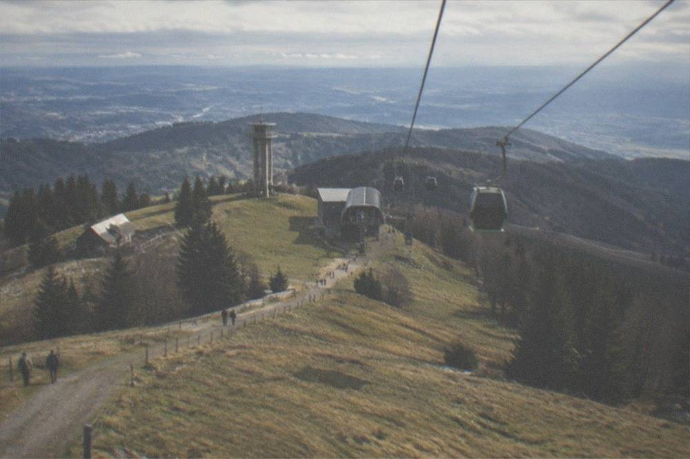 Cable car cabins moving up the green Schauinsland mountainside above Freiburg