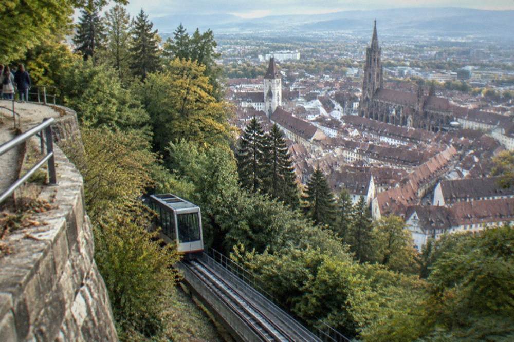 Inclined funicular lift rising along the Schlossberg slope above Freiburg rooftops
