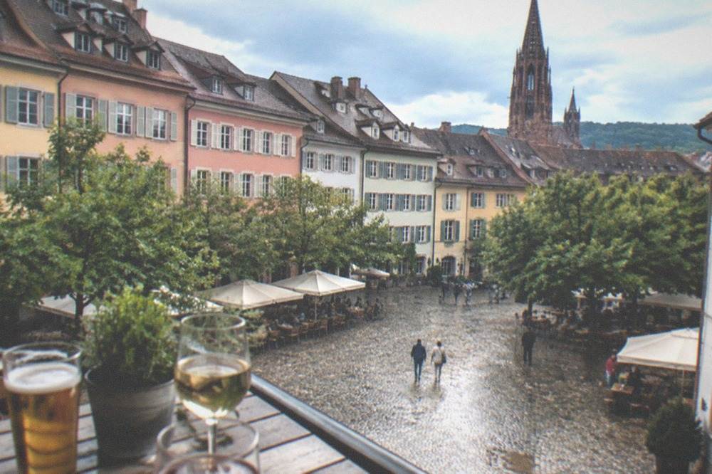 Glasses of beer and regional wine on a wooden table with a view over city rooftops