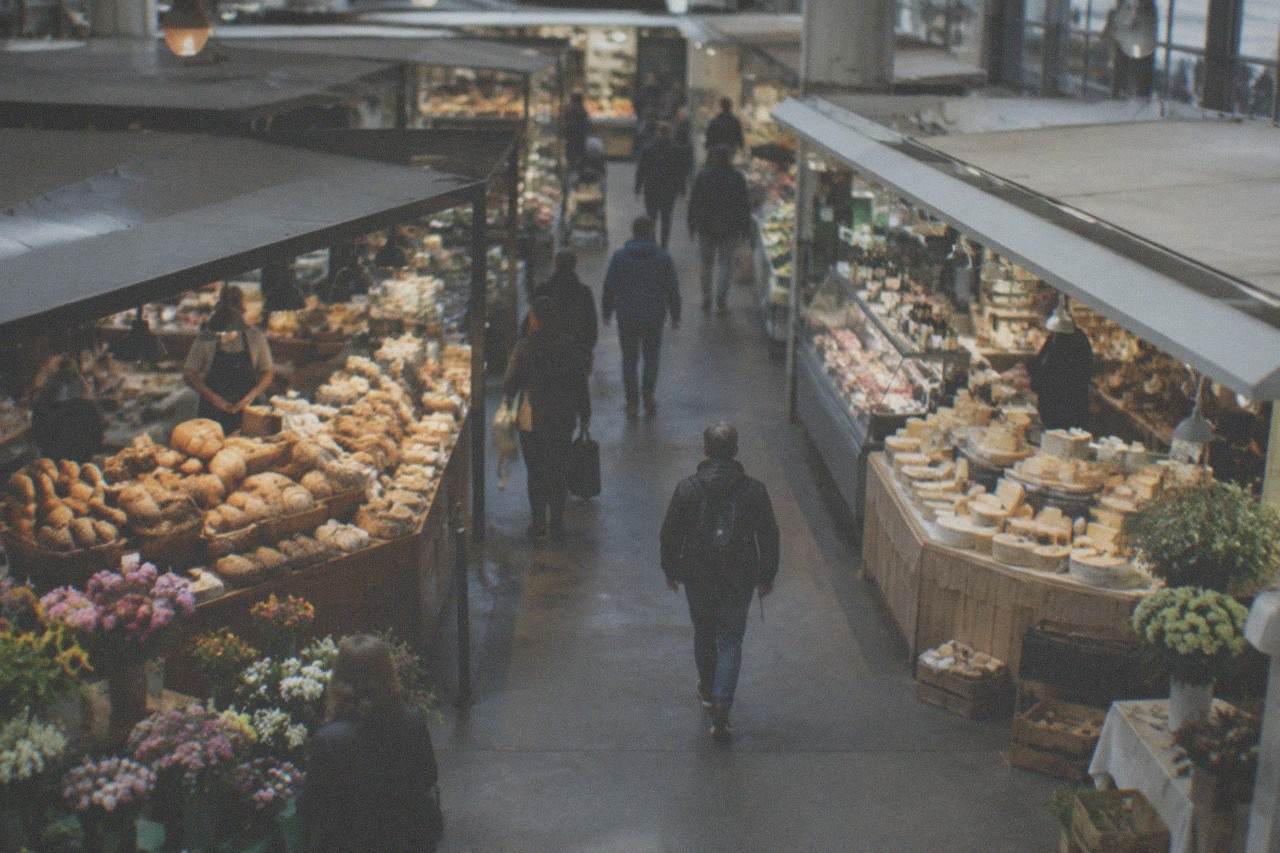 Market stalls with bread, cheese and flowers in front of a Gothic cathedral in a southern German city