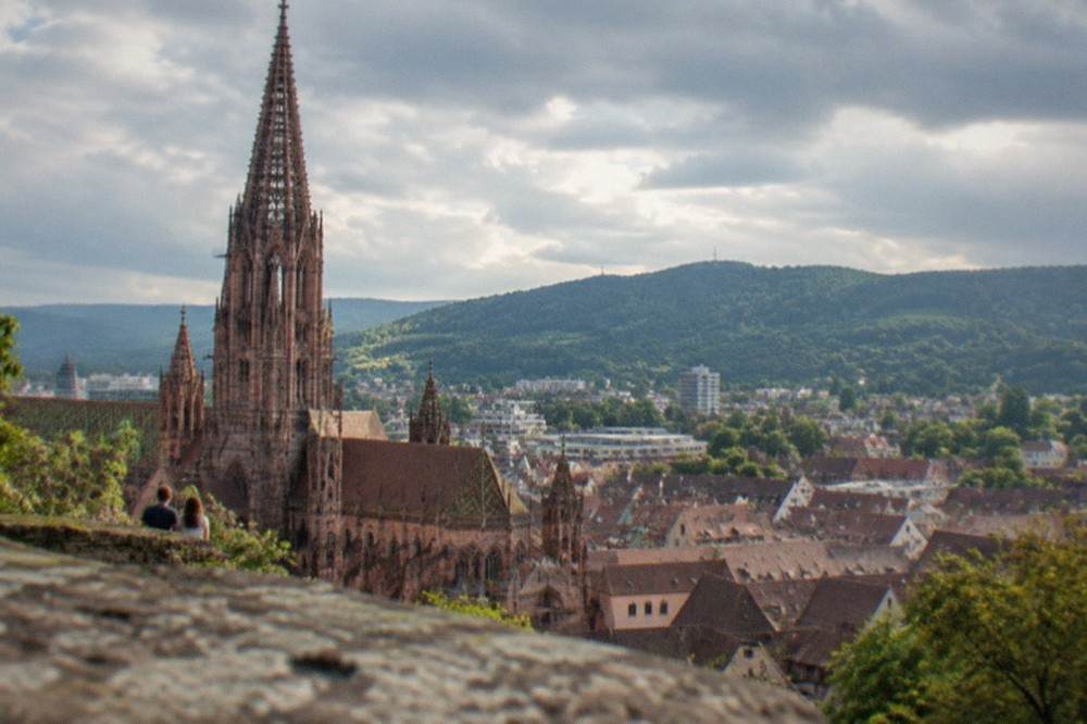 View over Freiburg rooftops toward the Black Forest hills from the Schlossberg