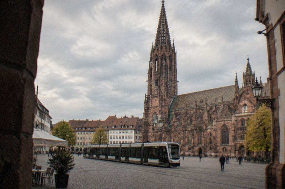 Freiburg tram passing through the old town with the minster in the background