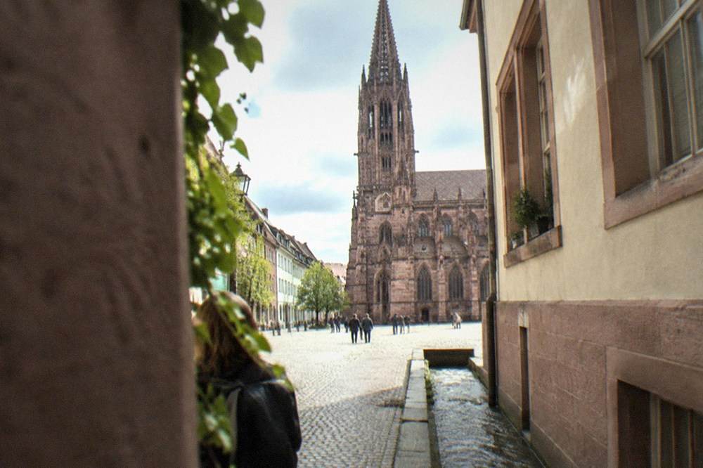 Narrow lane in Freiburg old town with a small water channel running alongside the cobbles