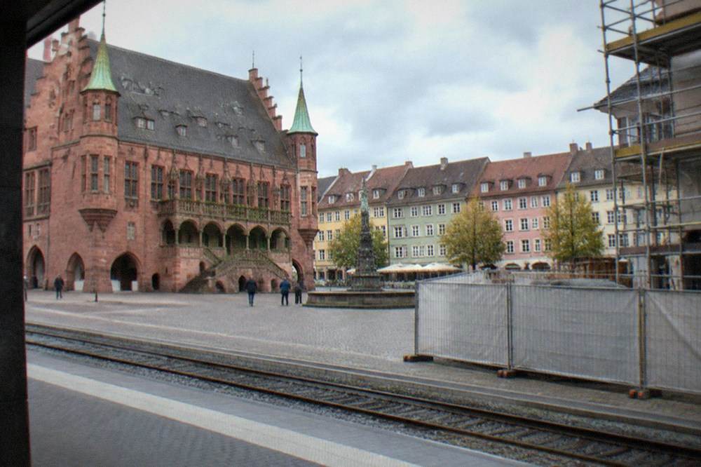 Platform edge with construction hoarding and scaffolding alongside the tracks