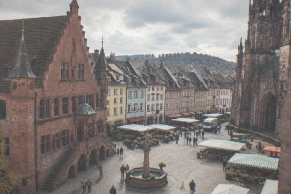 Market stalls and the red sandstone cathedral facade on a cobbled square