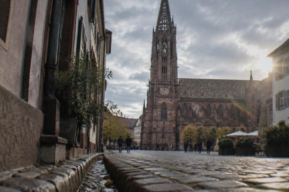 Narrow cobblestone lane in the Freiburg old town with small gutters of running water beside the curb