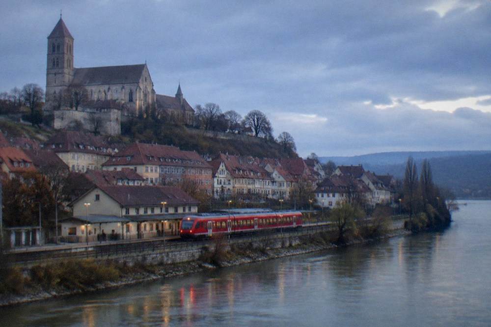 A red regional train waiting at Breisach station beside the Rhine