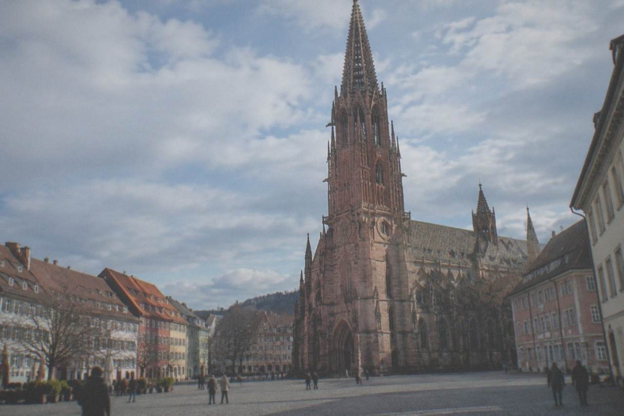 Freiburg Münster rising above red-roofed old town buildings on a clear day