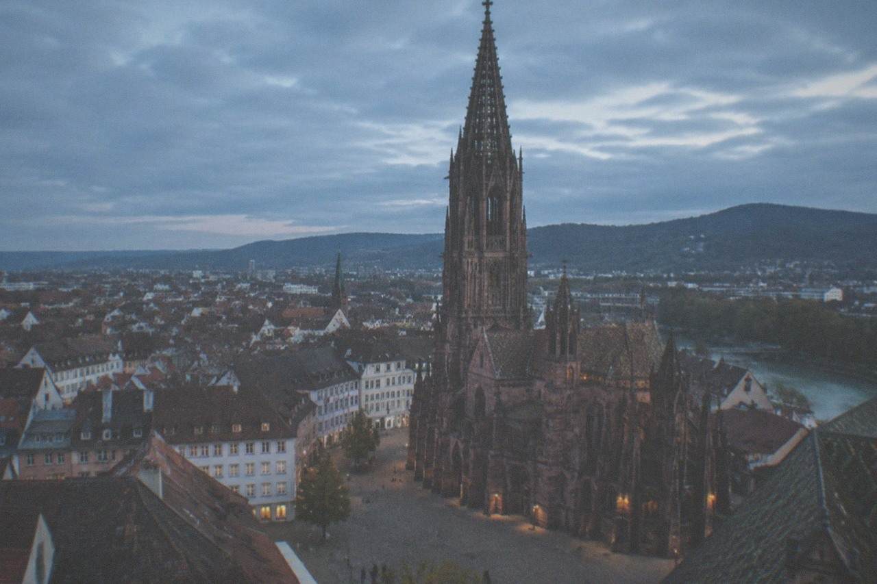 Freiburg Minster tower rising above red rooftops of the old town