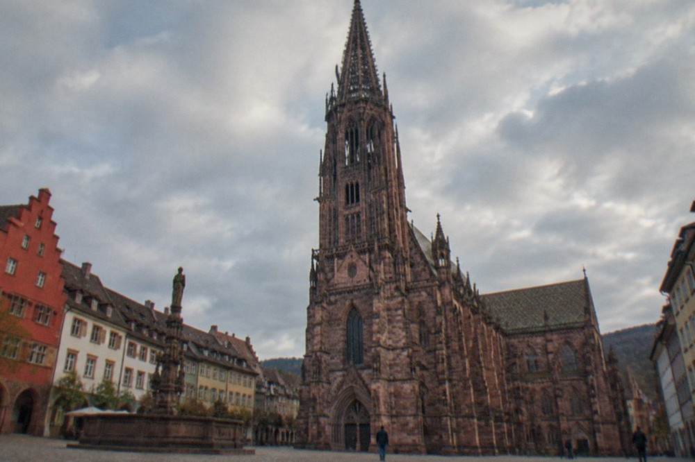 Cobbled square in Freiburg old town with historic guild houses and a market fountain