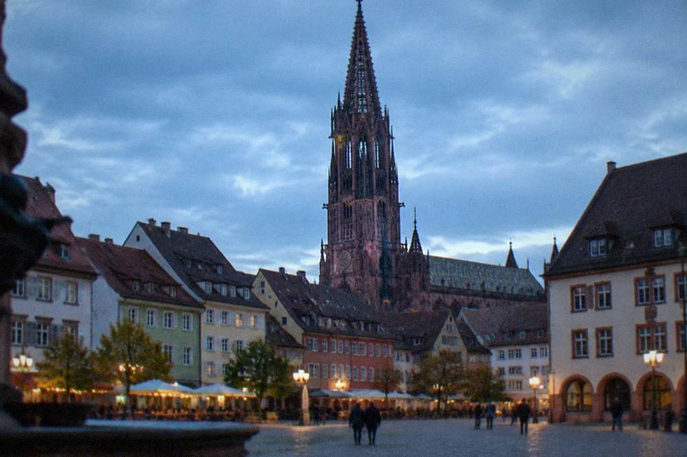 Gothic cathedral tower seen above narrow old town rooftops