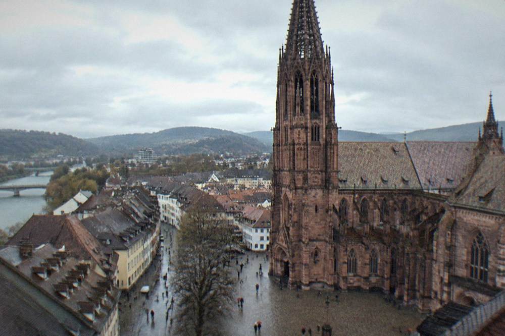Rain-washed cobblestone lane in Freiburg old town with water running in the street gutters