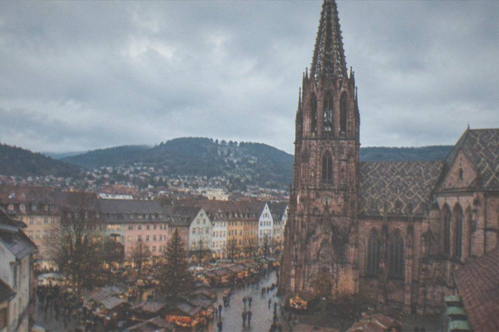 Festive wooden stalls of the Freiburg Christmas market beside the old town buildings in early dusk