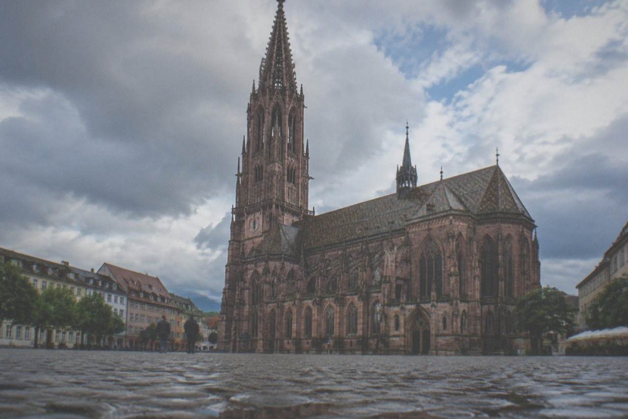 Freiburg minster and rooftops under a mix of sun and cloud above the upper Rhine plain