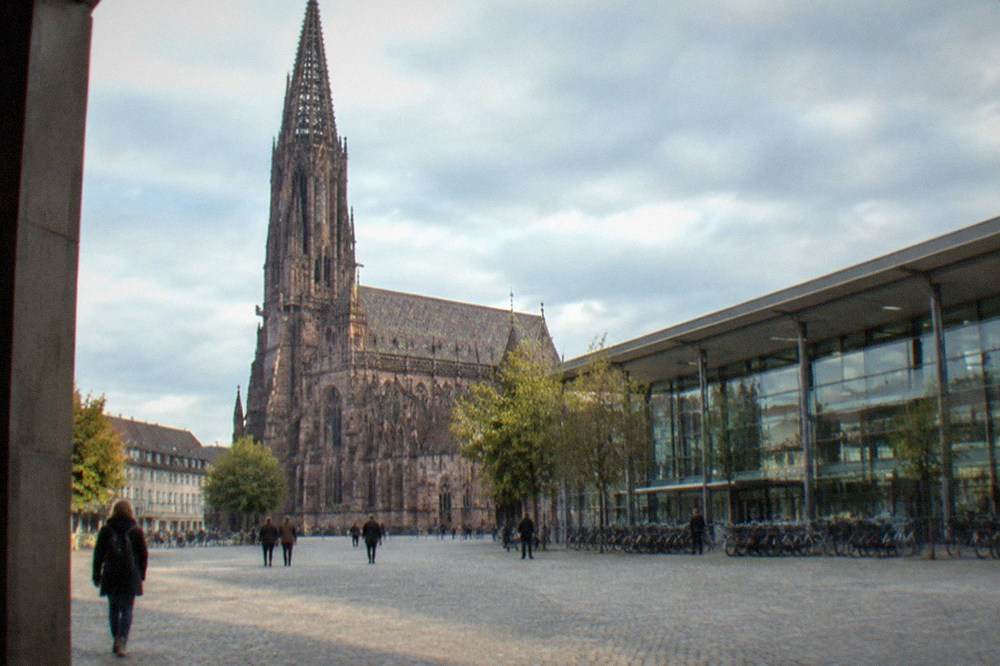 The modern glass front of Freiburg main station with bicycles parked outside the entrance