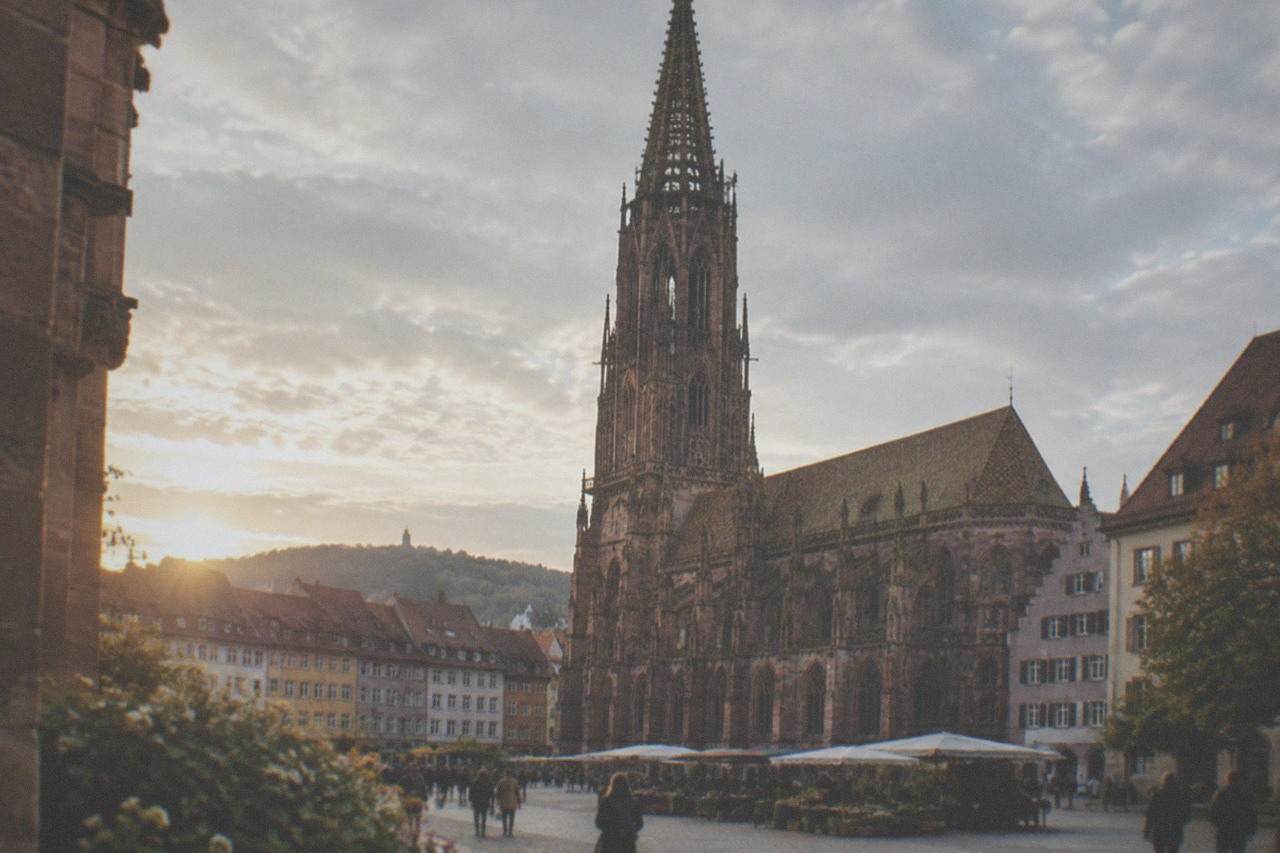 Freiburg Minster rising above red rooftops and the market square on a clear morning