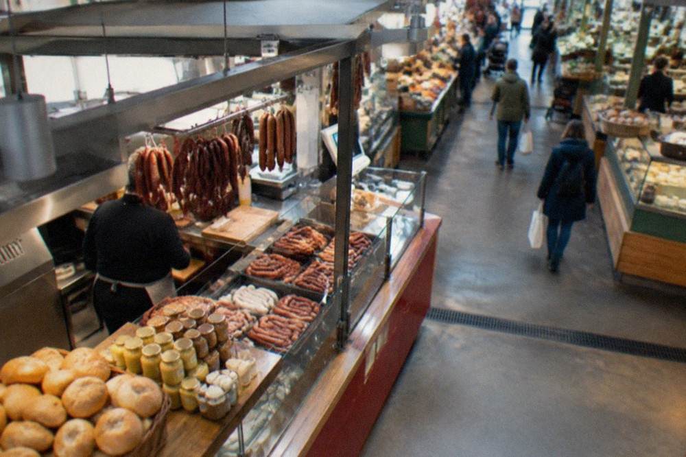 Sausage stall at the Münstermarkt with bread rolls and mustard jars in the foreground.