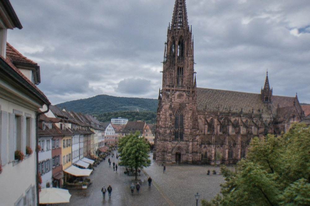 Cobbled shopping street in Freiburg old town lined with small storefronts