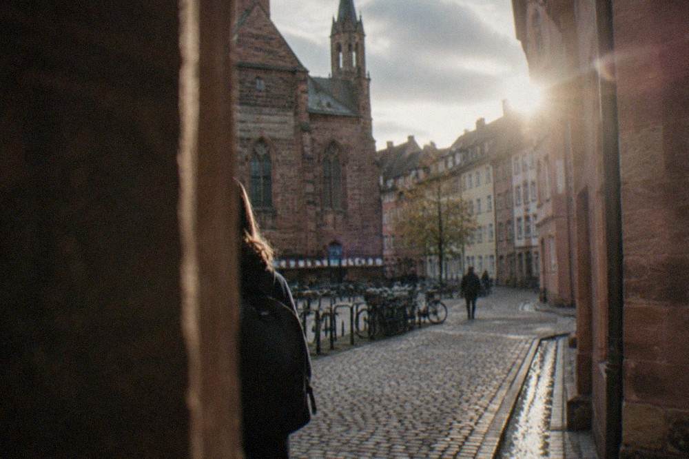Cobbled square in the old town with historic stone university buildings and bicycle racks