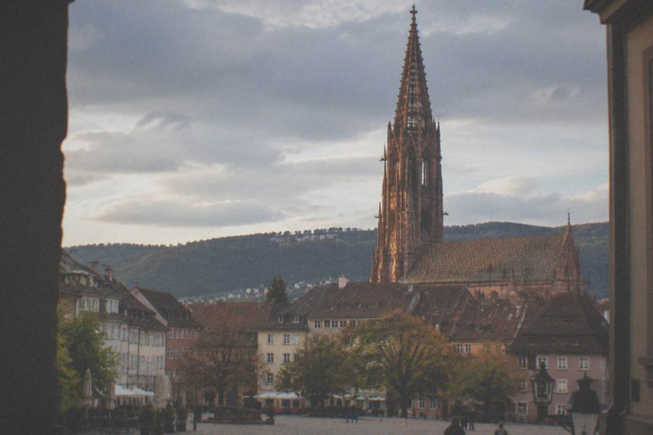 View over Freiburg old town rooftops with the Munster tower rising above the Black Forest foothills