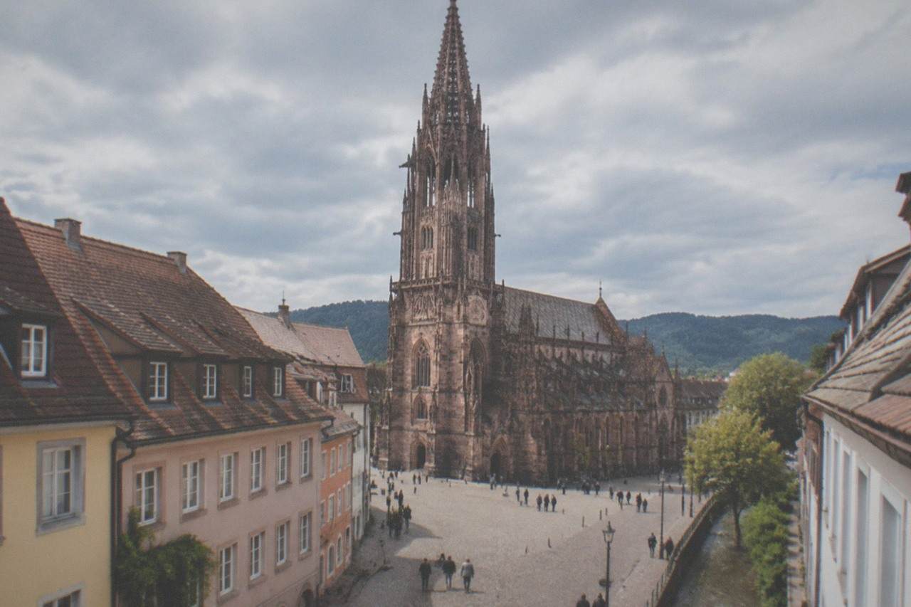 Cobblestone street with pastel facades and a small stream running along the gutter in central Freiburg